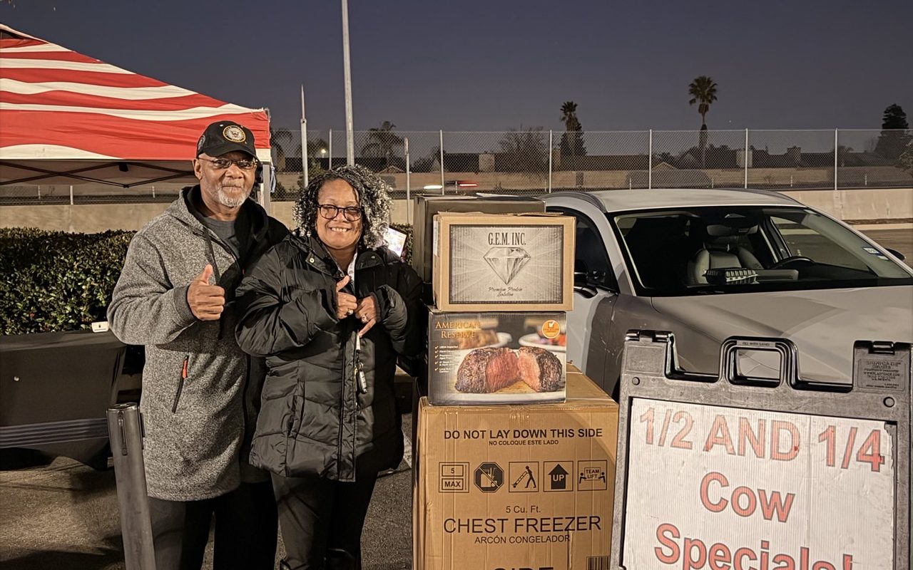 Two customers at an evening sale beside the specials signs